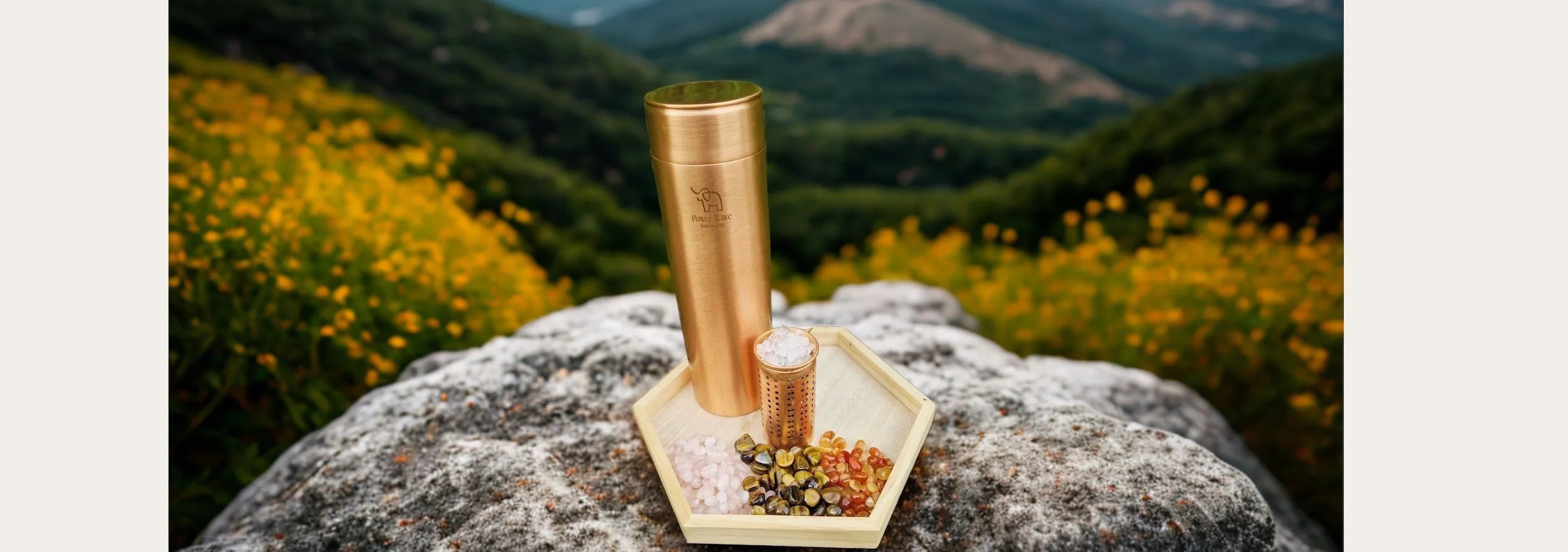 Kupfertrinkflasche aus Indien, handgemacht und mit Edelsteinen für Kristallwasser nach deiner Wahl vor einer Alpenkulisse.